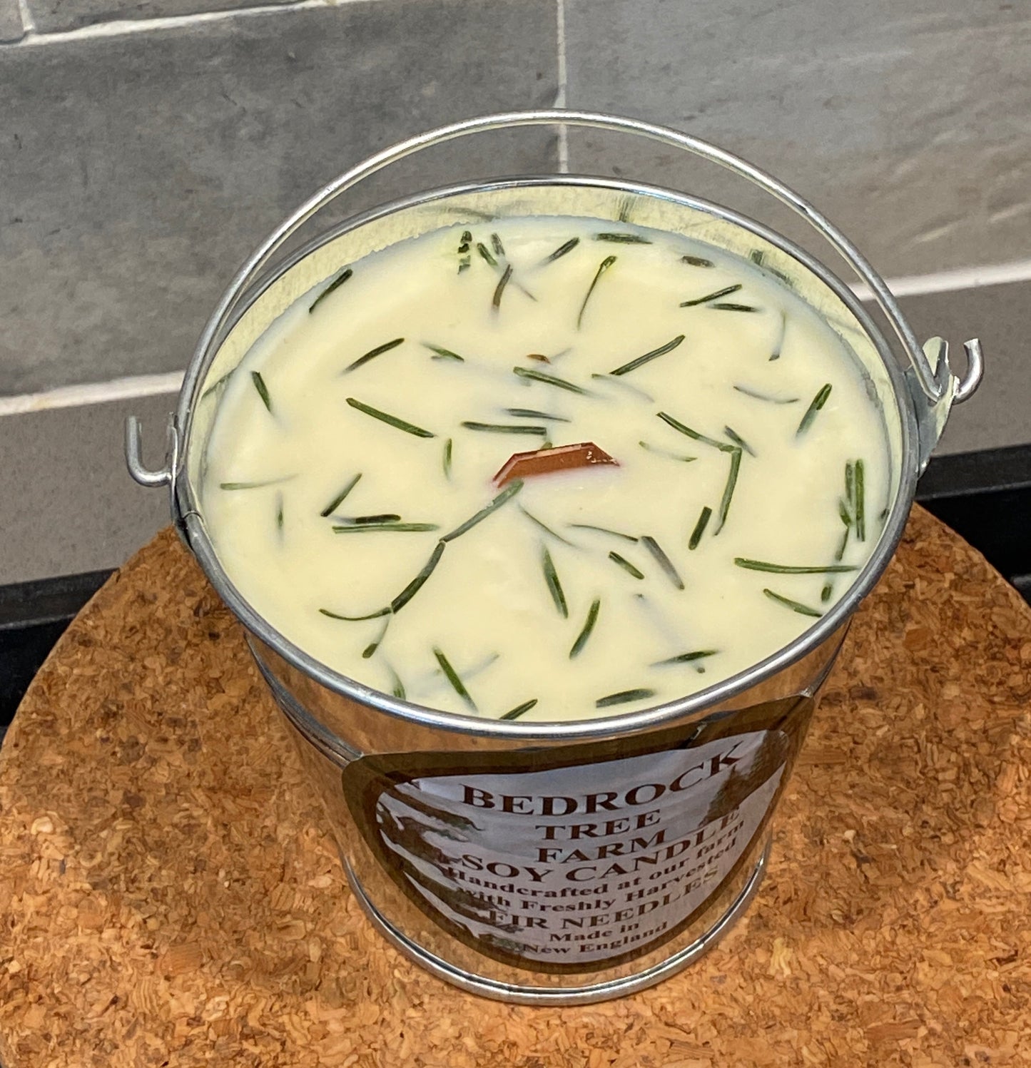 Galvanized Pail with wooden wick.  Won't rust.  Reusable.